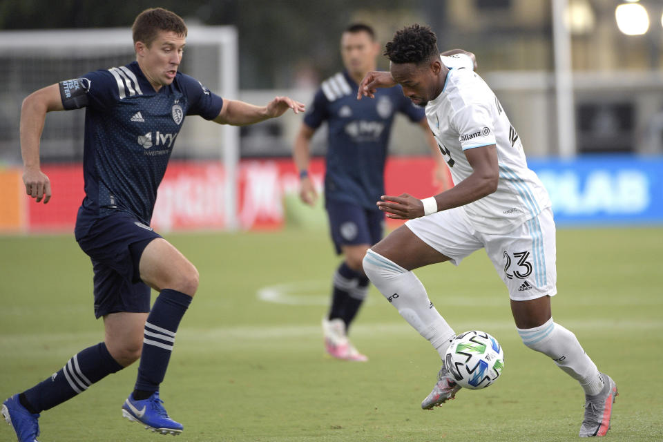 Sporting Kansas City defender Matt Besler, left, and Minnesota United forward Mason Toye (23) vie for the ball during the first half of an MLS soccer match Sunday, July 12, 2020, in Kissimmee, Fla. (AP Photo/Phelan M. Ebenhack)