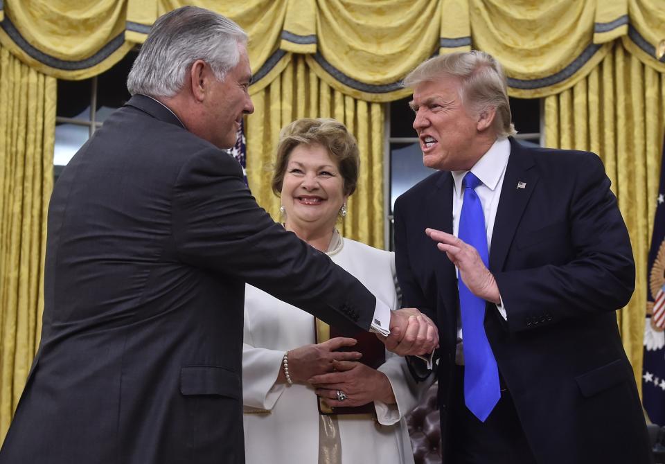 US President Donald Trump (R) shakes hands with Rex Tillerson (L) as Tillerson's wife Renda St. Clair look on after Tillerson was sworn in as Secretary of State in the Oval Office at the White House in Washington, DC, on February 1, 2017. President Trump notched a victory with confirmation of Rex Tillerson as his secretary of state, but opposition Democrats girded for battle over several other nominations, including his pick for the US Supreme Court.&nbsp;