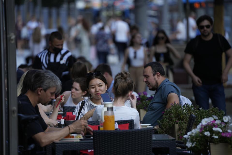 People relax after a hot day at an outdoor terrace of a restaurant in Moscow, Russia, Wednesday, July 14, 2021. The Russian capital recorded new record temperatures amid a heat wave this month with today's temperatures forecast 33 degrees Celsius (91,4 Fahrenheit). (AP Photo/Alexander Zemlianichenko)