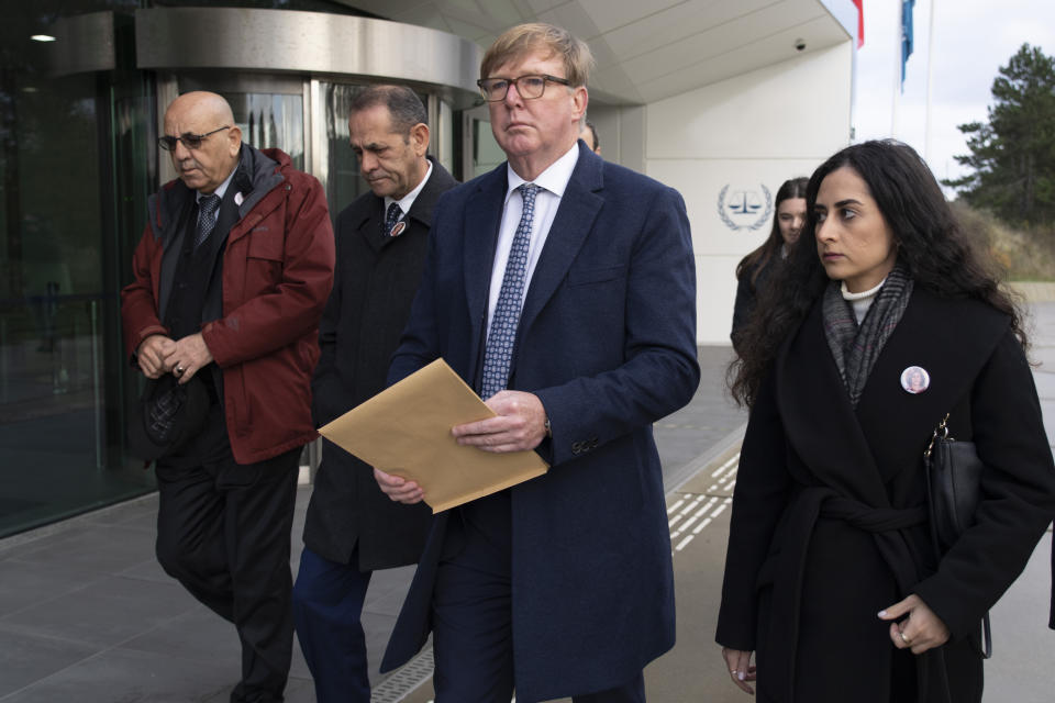 Rodney Dixon, lawyer for Al Jazeera, center with letter, and Lina Abu Akleh, niece of fatally shot Al Jazeera journalist Shireen Abu Akleh, right, walk to to the International Criminal Court in The Hague, Netherlands, Tuesday, Dec. 6, 2022, to present a letter requesting a formal investigation into the killing. Palestinian officials, Abu Akleh's family and Al Jazeera accuse Israel of intentionally targeting and killing the 51-year-old journalist, a claim Israel denies. (AP Photo/Peter Dejong)