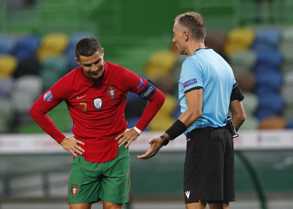 FILE - In this Wednesday, Oct. 7, 2020 file photo Portugal's Cristiano Ronaldo, left, reacts as he speaks with referee Paolo Valeri during the international friendly soccer match between Portugal and Spain at the Jose Alvalade stadium in Lisbon. The Portuguese soccer federation says Cristiano Ronaldo has tested positive for the coronavirus. The federation says Ronaldo is doing well and has no symptoms. He has been dropped from the country's Nations League match against Sweden on Wednesday. (AP Photo/Armando Franca, File)