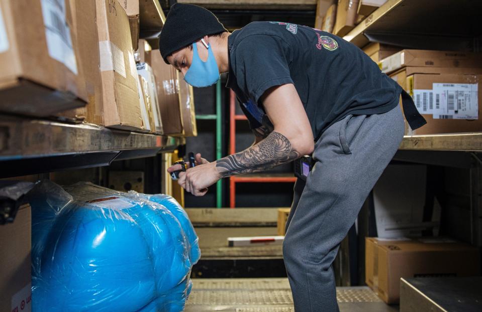 A UPS worker processes packages in this undated photo. UPS has hired additional seasonal workers, increased square footage across the country and expanded weekend service to prepare for a busy holiday season.