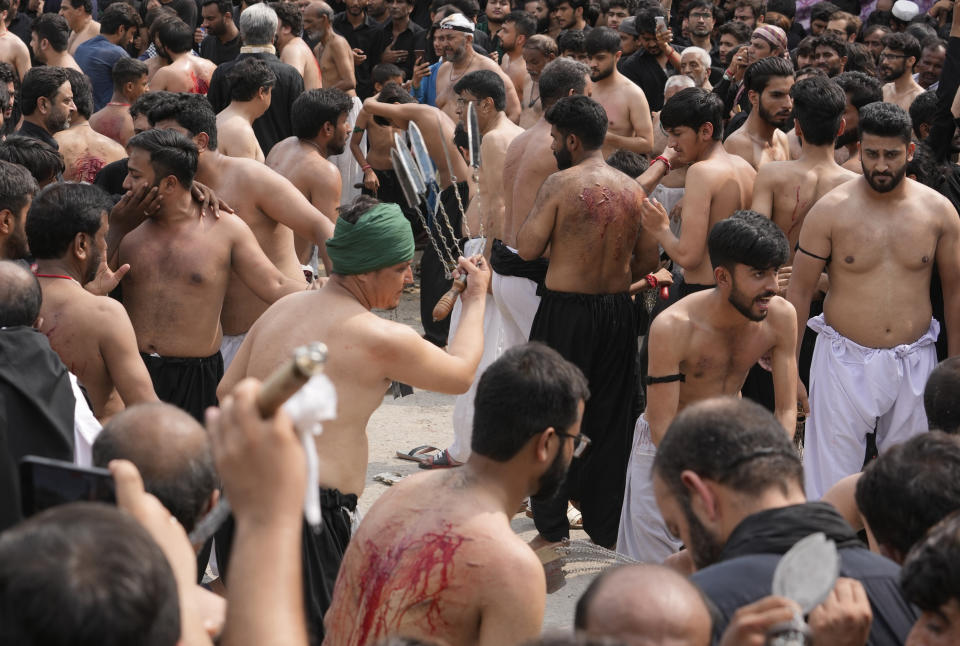 Shiite Muslims flagellate themselves with knifes on chains during a procession to mark Ashoura, in Islamabad, Pakistan, Friday, July 28, 2023. Ashoura is the Shiite Muslim commemoration marking the death of Hussein, the grandson of the Prophet Muhammad, at the Battle of Karbala in present-day Iraq in the 7th century. (AP Photo/Rahmat Gul)