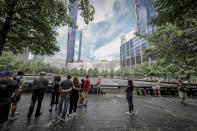 <p>Visitors gather to pay tribute to the victims of the 9/11 attacks near one of two reflecting pools at the National September 11 Memorial & Museum on Aug. 18, 2018. (Photo: Gordon Donovan/Yahoo News) </p>