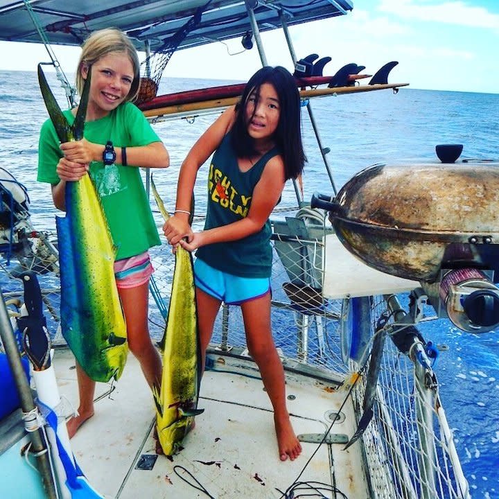 "We are a family of four who live on a sailboat currently in the South Pacific. Our daughters know more about how to fish than most grown men. They're keen on which lures to use, line to put out, how to properly gaff a fish (go for the eyeball) and how to 'nicely' kill a fish. Pictured here is their double hook up on the way to the Cook Islands. Our youngest daughter doesn't look too thrilled as her fish had just slapped her in the face. I love watching them give tips and advice to 'real' fishermen at port who have heard about their success. Teach your daughters to fish and they will provide."
