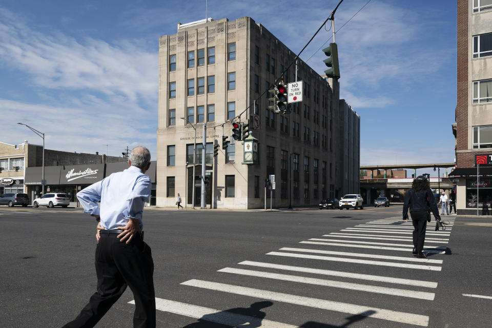 People walk by the offices of the Diocese of Rockville Centre, Thursday, Oct. 1, 2020, in Rockville Centre, N.Y. The diocese filed for bankruptcy on Thursday because of financial pressure from lawsuits over past sexual abuse by clergy members. (AP Photo/Mark Lennihan)