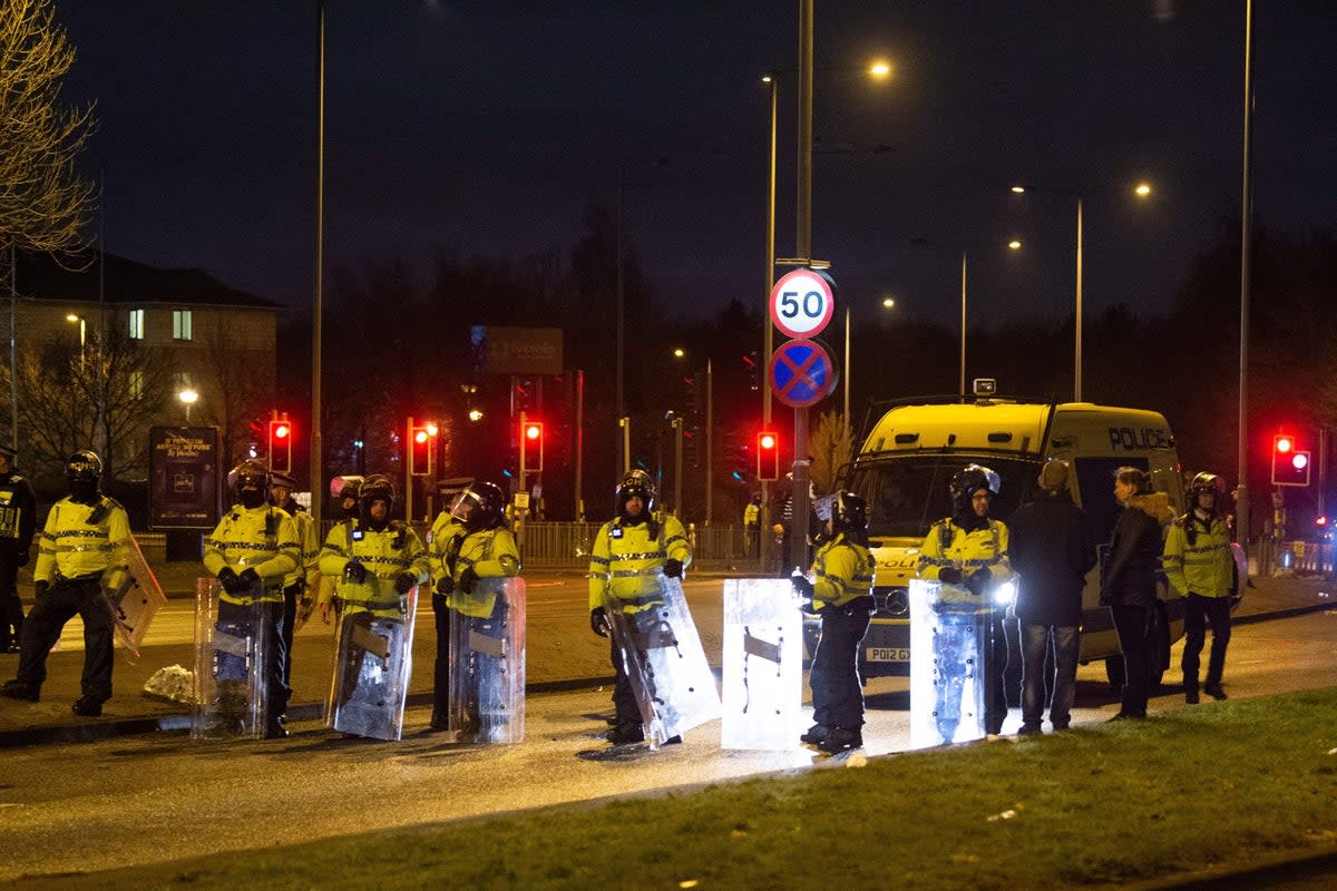 Police in riot gear attend the protest outside the Suites Hotel in Knowsley (PA Wire)