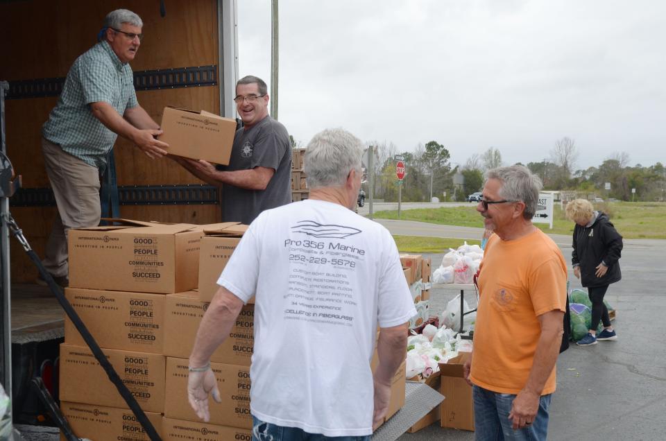 Staff and volunteers with Religious Community Services unload boxes of food to be handed out to local residents during an Operation Outpost food giveaway in Bridgeton.