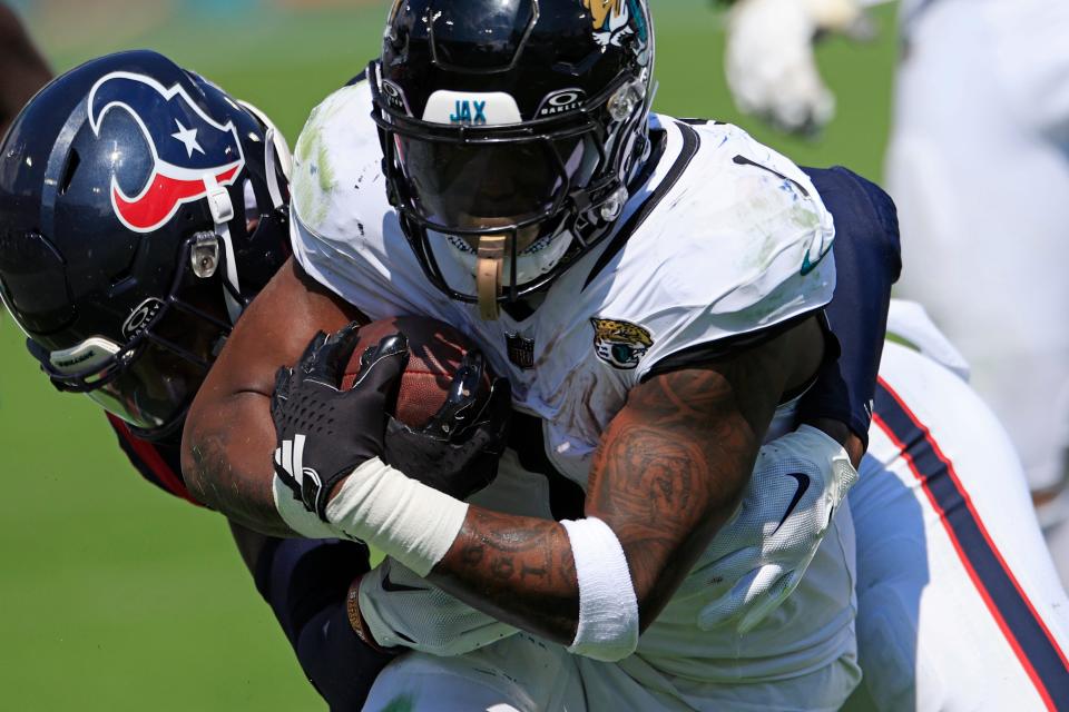 Jacksonville Jaguars running back Travis Etienne Jr. (1) is tackled by Houston Texans safety Eric Murray (23) during the third quarter of an NFL football matchup Sunday, Sept. 24, 2023 at EverBank Stadium in Jacksonville, Fla.