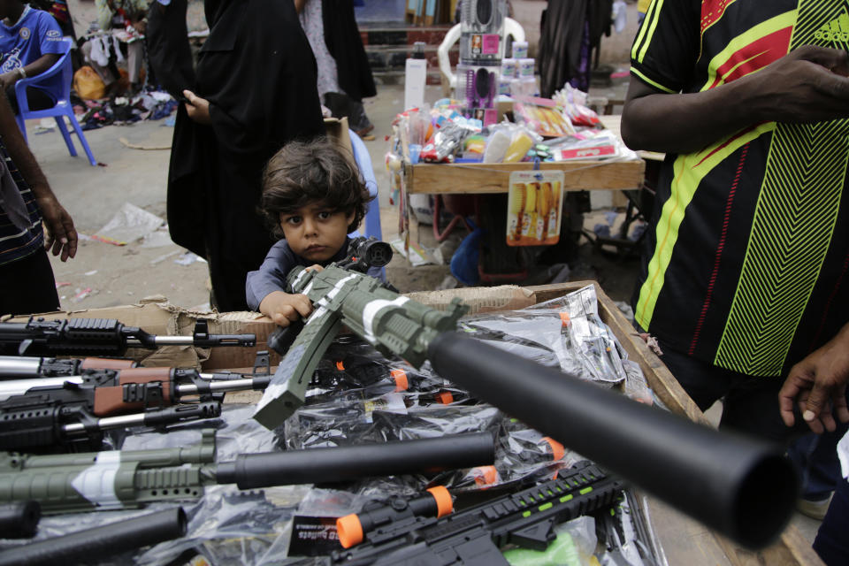 A child plays with a toy gun at a street market in Mogadishu, Somalia, Wednesday, April 19, 2023, as preparations are made for the Muslim holiday of Eid al-Fitr, next Friday, which marks the end of the holy fasting month of Ramadan. (AP Photo/Farah Abdi Warsameh)