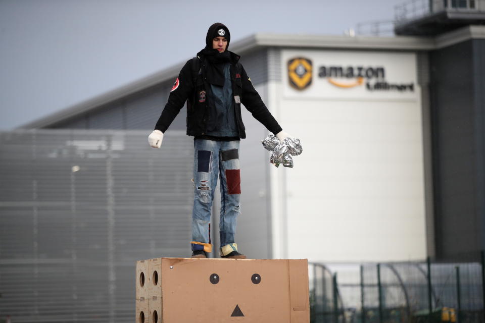 An Extinction Rebellion activist stands on an effigy during a protest outside the Amazon Fulfilment Centre in Altrincham, near Manchester, Britain, November 26, 2021. REUTERS/Carl Recine