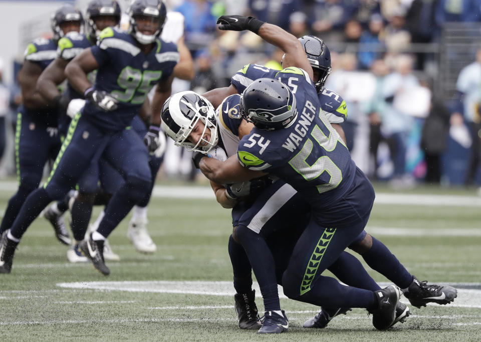 Los Angeles Rams wide receiver Cooper Kupp, center left, is hit hard by Seattle Seahawks linebacker Bobby Wagner (54) and Barkevious Mingo (obscured) during the first half of an NFL football game, Sunday, Oct. 7, 2018, in Seattle. Cooper left the game with an injury after the play. (AP Photo/Elaine Thompson)