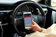 Yasmin Perveen, one of the pioneer women "captains" of Careem, checks her work app before driving her car in Islamabad, Pakistan December 7, 2016. REUTERS/Faisal Mahmood