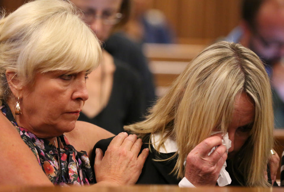 June Steenkamp, right, mother of the late Reeva Steenkamp, is comforted by family friend, Jenny Strydom, left, during the murder trial of Oscar Pistorius, during questioning on mobile phone text messages between Pistorius and girlfriend Steenkamp, in court in Pretoria, South Africa, Tuesday, March 25, 2014. Pistorius is charged with the Valentines Day 2013 shooting death of his girlfriend Reeva Steenkamp. (AP Photo/Siphiwe Sibeko, Pool)