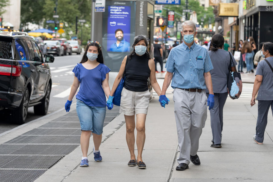 A family wears masks and gloves while walking in New York City. (Alexi Rosenfeld/Getty Images)