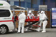 Medical workers wearing protective gears carry a patient infecting with a new coronavirus to a hospital in Chuncheon, South Korea, Saturday, Feb. 22, 2020. South Korea on Saturday reported a six-fold jump in viral infections in four days to 346, most of them linked to a church and a hospital in and around the fourth-largest city where schools were closed and worshipers and others told to avoid mass gatherings. (Lee Sang-hak/Yonhap via AP)