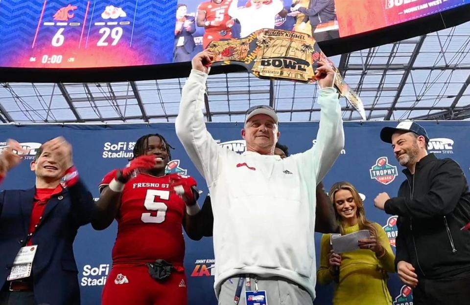 Fresno State head coach Jeff Tedford, center, lifts the championship belt after Fresno State defeated Washington State 29-6 at the Jimmy Kimmel LA Bowl Saturday, Dec. 17, 2022 in Inglewood, CA. Joining the celebration, from left, Fresno State President Saúl Jiménez-Sandoval, game MVPs defensive lineman Devo Bridges and (behind Tedford) running back Jordan Mims, ABC on-field reporter Molly McGrath and Kimmel.