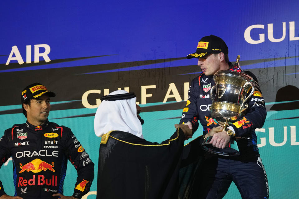 First place, Red Bull driver Max Verstappen of the Netherlands, right, receives his trophy on the podium during the Formula One Bahrain Grand Prix at the Bahrain International Circuit in Sakhir, Bahrain, Saturday, March 2, 2024. (AP Photo/Darko Bandic)