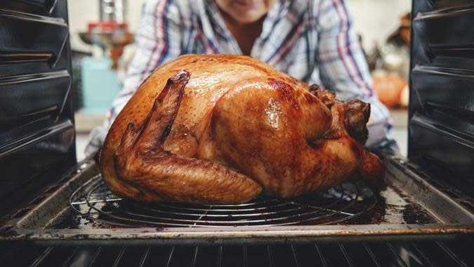 A cooked turkey being removed from an oven. (iStock.com)