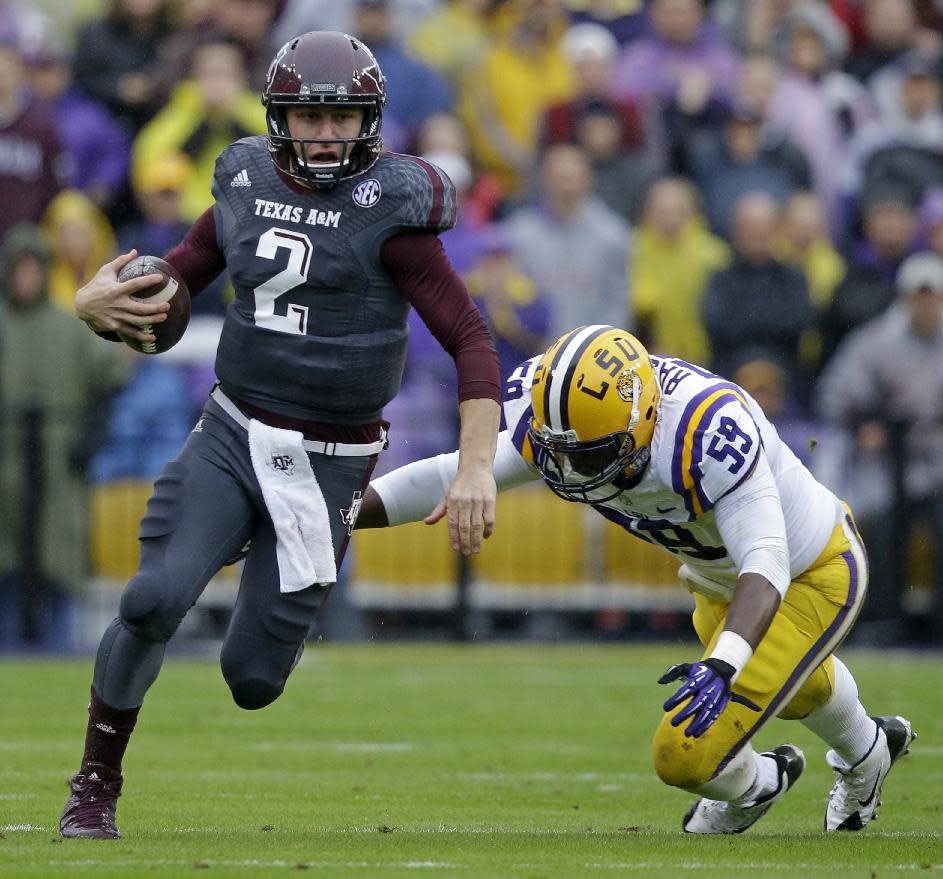 FILE - In this Nov. 23, 2013 file photo, Texas A&M quarterback Johnny Manziel (2) scrambles as LSU defensive end Jermauria Rasco (59) tries to tackle in the first half of an NCAA college football game in Baton Rouge, La. Manziel was all business Friday, Feb. 21, 2014, at the NFL scouting combine. He walked to the podium, provided mostly thoughtful, deliberate answers and even suggested some of his previous quotes have been overblown. (AP Photo/Gerald Herbert, File)