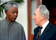 President Nelson Mandela exchanges views with former Israeli Prime Minister Shimon Peres after their meeting in Cape Town, in this October 20, 1996 file photo. REUTERS/Stringer/Files