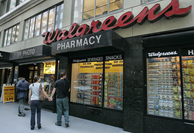 FILE - In this June 26, 2006 file photo, window shoppers look at a Walgreens storefront in San Francisco. Walgreens says it will close five more stores in San Francisco next month because of organized retail theft. The drugstore chain has closed at least 10 stores in the city since the start of 2019. (AP Photo/Ben Margot, File)