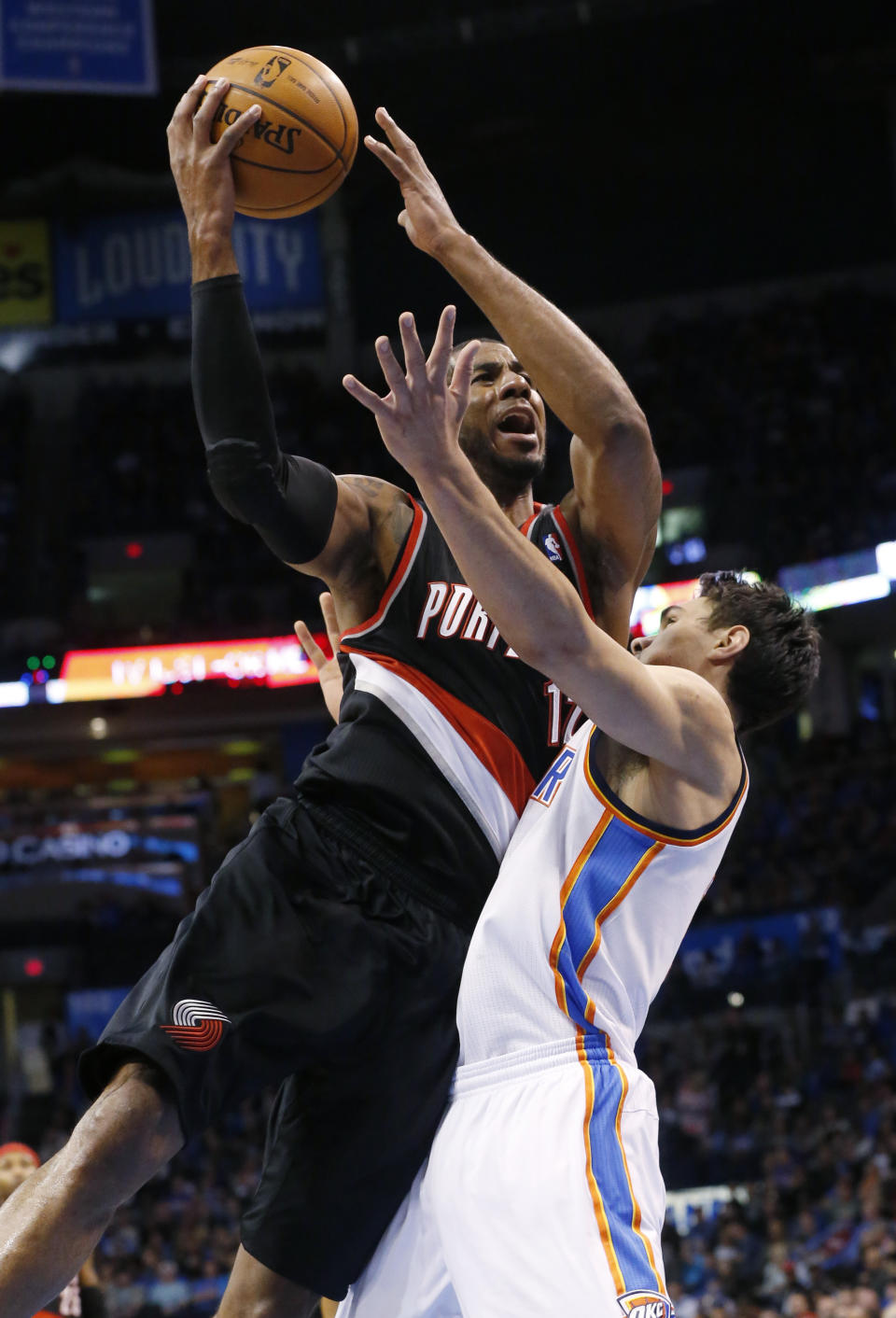 Portland Trail Blazers forward LaMarcus Aldridge, left, shoots over Oklahoma City Thunder center Steven Adams, right, in the first quarter of an NBA basketball game in Oklahoma City, Tuesday, Jan. 21, 2014. (AP Photo/Sue Ogrocki)