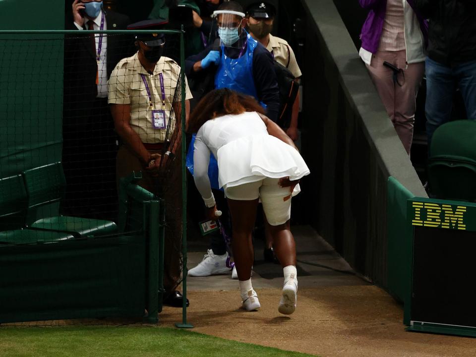 Serena Williams clutches her right leg as she leaves the court with an apparent injury.