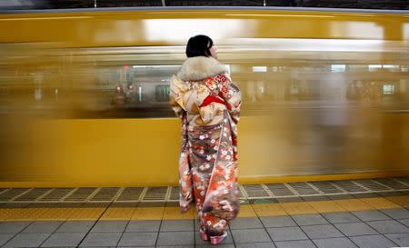 FILE PHOTO: A Japanese woman wearing a kimono waits for her train after Coming of Age Day celebration ceremony in Tokyo, Japan January 9, 2017. REUTERS/Kim Kyung-Hoon/File Photo