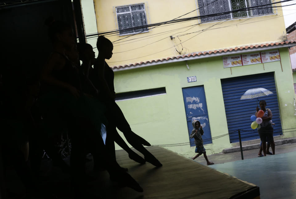 Dancers from the Afro Reggae center perform before members of London's Royal Opera House in the Vigario Geral slum of Rio de Janeiro, Brazil, Saturday, March 2, 2013. This past week Royal Ballet dancers shared their knowledge and advice with promising artists during an education symposium between the company and the cultural arts center Afro Reggae. (AP Photo/Silvia Izquierdo)