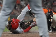 Cincinnati Reds' Stuart Fairchild, left, slides home to score on an inside-the-park home run, next to San Francisco Giants catcher Jakson Reetz during the eighth inning of a baseball game in San Francisco, Friday, May 10, 2024. (AP Photo/Jeff Chiu)