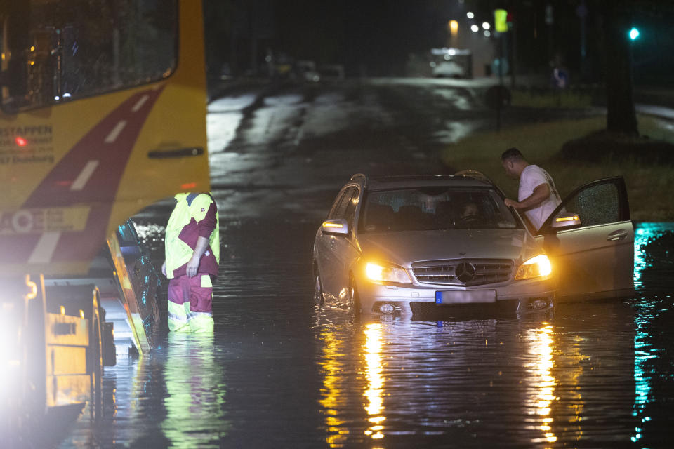A car is recovered from a flooded underpass by a towing service following heavy rain, early Friday, June 23, 2023, in Duisburg, Germany. (Christoph Reichwein/dpa via AP)