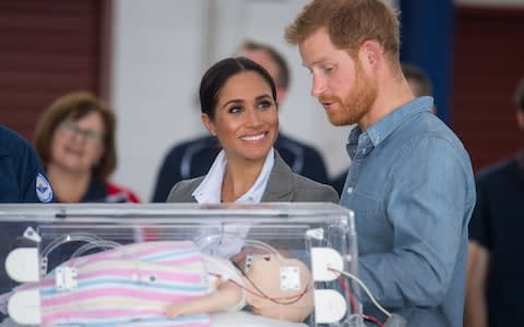 Meghan, Duchess of Sussex and Prince Harry, Duke of Sussex look at medical training equipment during a naming and unveiling ceremony for the new Royal Flying Doctor Service aircraft at Dubbo Airport  - Credit: Getty