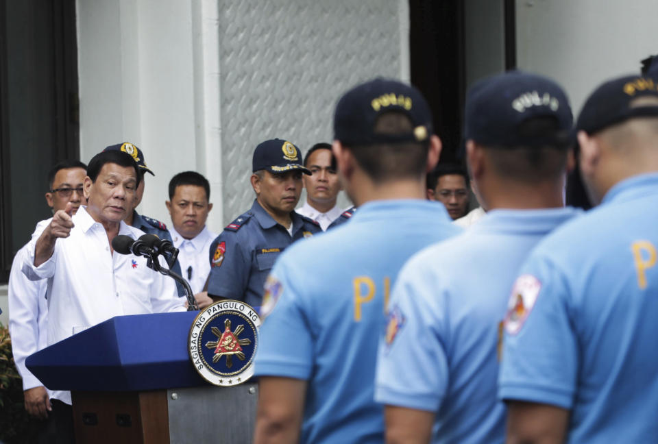 In this photo provided by the Presidential Photographers Division, Malacanang Palace, Philippine President Rodrigo Duterte, left, berates erring policemen during an audience at the Presidential Palace grounds in Manila, Philippines, Tuesday, Feb. 9, 2017. Duterte angrily berated more than 200 allegedly erring policemen and said he would send them to a southern island to fight extremists dreaded for their beheadings. Duterte's expletive-filled outburst against the officers at the palace was his latest tirade against a police force that he has called "rotten to the core." He recently banned the national police from carrying out his anti-drug campaign after a group of officers used the crackdown as a cover to kidnap and kill a South Korean man in an extortion scandal. (Robinson Ninal/Presidential Photographers Division, Malacanang Palace via AP)
