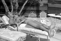 <p>Steve McQueen and his wife Neile Adams lie on a deck chair next to the pool at their Palm Springs, California home in 1963.</p>