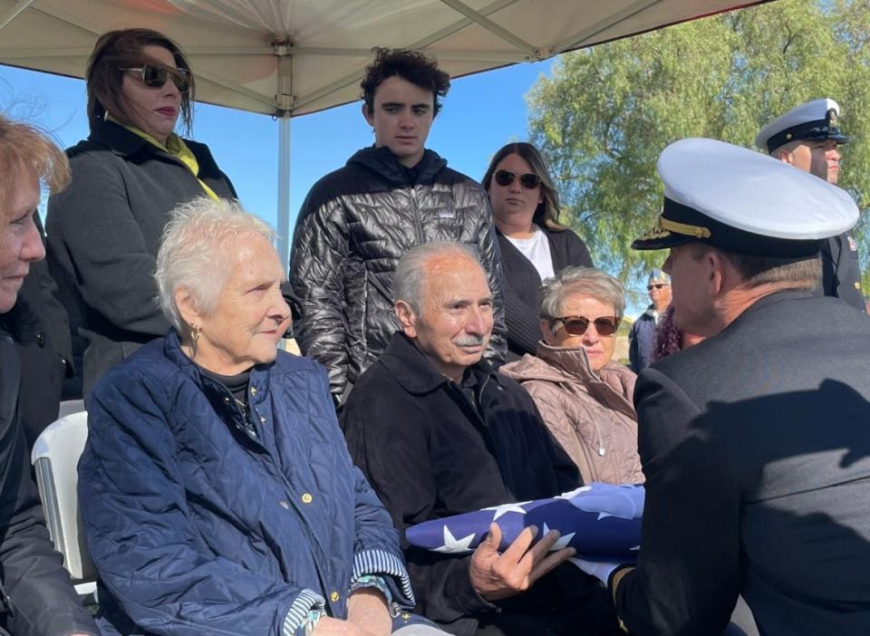 Ric Rufinelli, of Ventura, accepts a military flag ahead of his great uncle's Claude Ralph Garcia burial Dec. 11 at Ivy Lawn Memorial Park in Ventura. A U.S. Navy sailor, Garcia was killed in the Pearl Harbor attack at age 25 but his remains had not been identified until earlier this year.