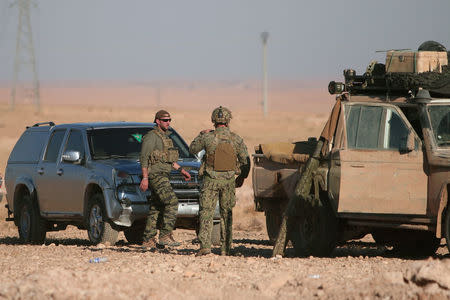 U.S. fighters stand near military vehicles, north of Raqqa city, Syria November 6, 2016. REUTERS/Rodi Said