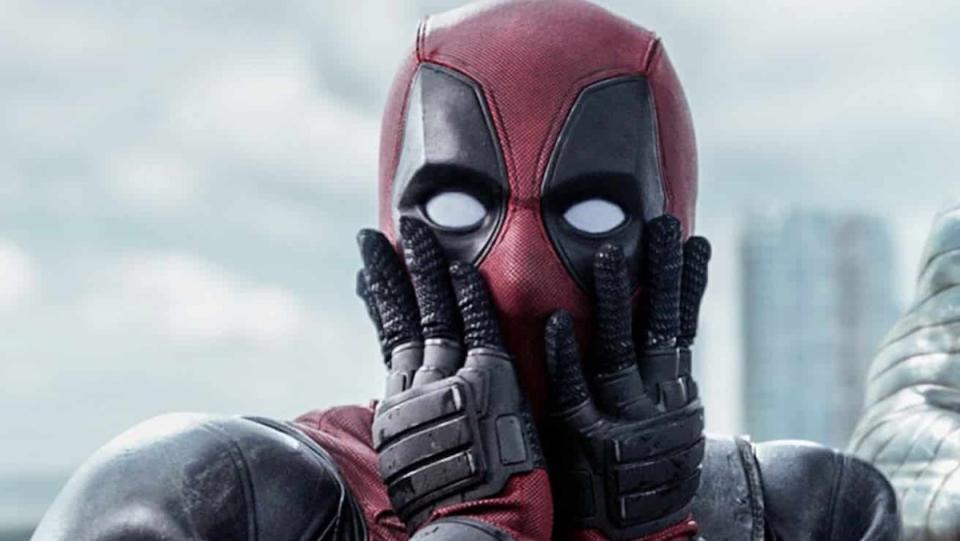 Deadpool looks shocked with his hands on his masked face