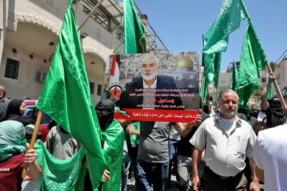 Palestinians carried a placard bearing the image of the leader of the militant Hamas group during a protest in the occupied West Bank city of Hebron