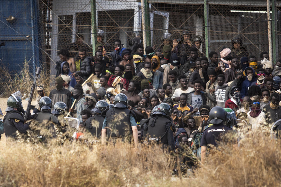 Riot police officers cordon off the area after migrants arrive on Spanish soil and crossing the fences separating the Spanish enclave of Melilla from Morocco in Melilla, Spain, Friday, June 24, 2022. Dozens of migrants stormed the border crossing between Morocco and the Spanish enclave city of Melilla on Friday in what is the first such incursion since Spain and Morocco mended diplomatic relations last month. (AP Photo/Javier Bernardo)