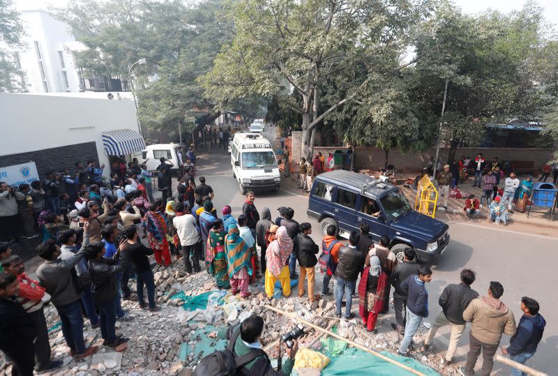 A hospital vehicle carries the body of a rape victim to her residence in New Delhi