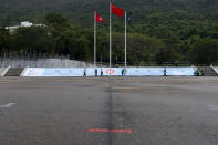 A red marking sign for police march is seen in front of a Chinese national flag and a Hong King flag on the National Security Education Day at a police school in Hong Kong Thursday, April 15, 2021. Beijing's top official in Hong Kong on Thursday warned foreign forces not to interfere with the "bottom line" of national security in Hong Kong, threatening retaliation even amid ongoing tensions between China and Western powers. (AP Photo/Vincent Yu)