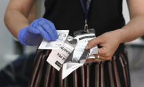 Boletas rotas son mostradas por una oficial de la corte electoral uruguaya durante un segundo escrutinio de votos anulados y observados tras el balotaje presidencial en Montevideo, Uruguay, el martes 26 de noviembre de 2019. (AP Foto/Matilde Campodonico)