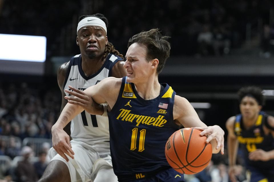 Marquette's Tyler Kolek, right, goes to the basket against Butler's Jahmyl Telfort during the second half of an NCAA college basketball game Tuesday, Feb. 13, 2024, in Indianapolis. (AP Photo/Darron Cummings)