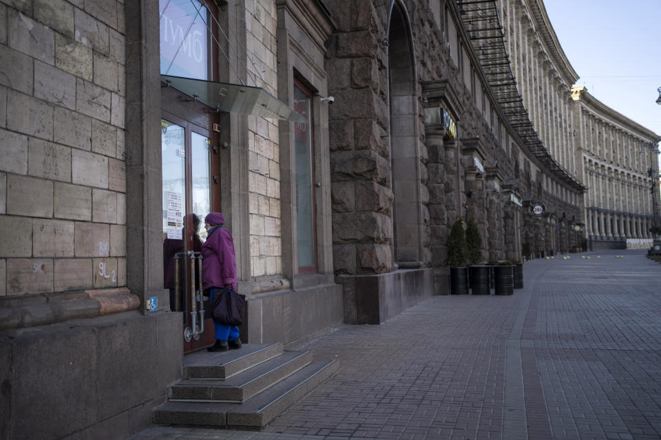 FILE - A woman tries to enter a bank that is closed due to the war against Russia, near Maidan Square, in Kyiv, Ukraine, March 18, 2022. Even as Ukraine celebrates recent battlefield victories, its government faces a looming challenge on the financial front: how to pay the enormous cost of the war effort without triggering out-of-control price spikes for ordinary people or piling up debt that could hamper postwar reconstruction. (AP Photo/Rodrigo Abd, File)