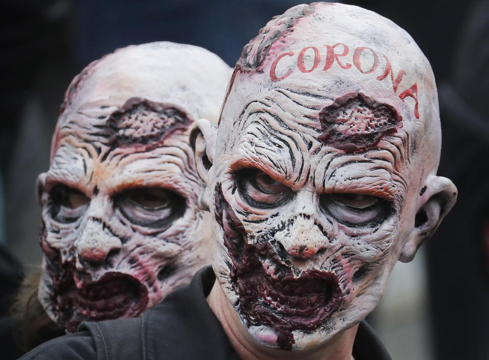 People wearing masks take part in a 'We Do Not Consent' rally at Trafalgar Square, organised by Stop New Normal, to protest against coronavirus restrictions, in London, Saturday, Sept. 26, 2020. (AP Photo/Frank Augstein)