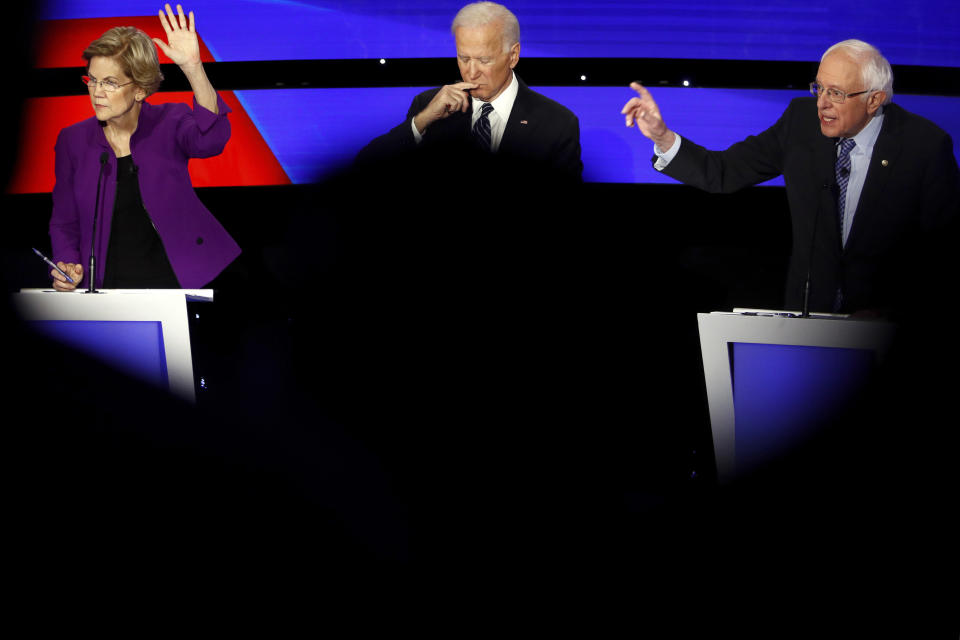 Democratic presidential candidate Sen. Elizabeth Warren, D-Mass., and Sen. Bernie Sanders, I-Vt., raise their hands to answer a question as Joe Biden pauses Tuesday, Jan. 14, 2020, during a Democratic presidential primary debate hosted by CNN and the Des Moines Register in Des Moines, Iowa. (AP Photo/Patrick Semansky)