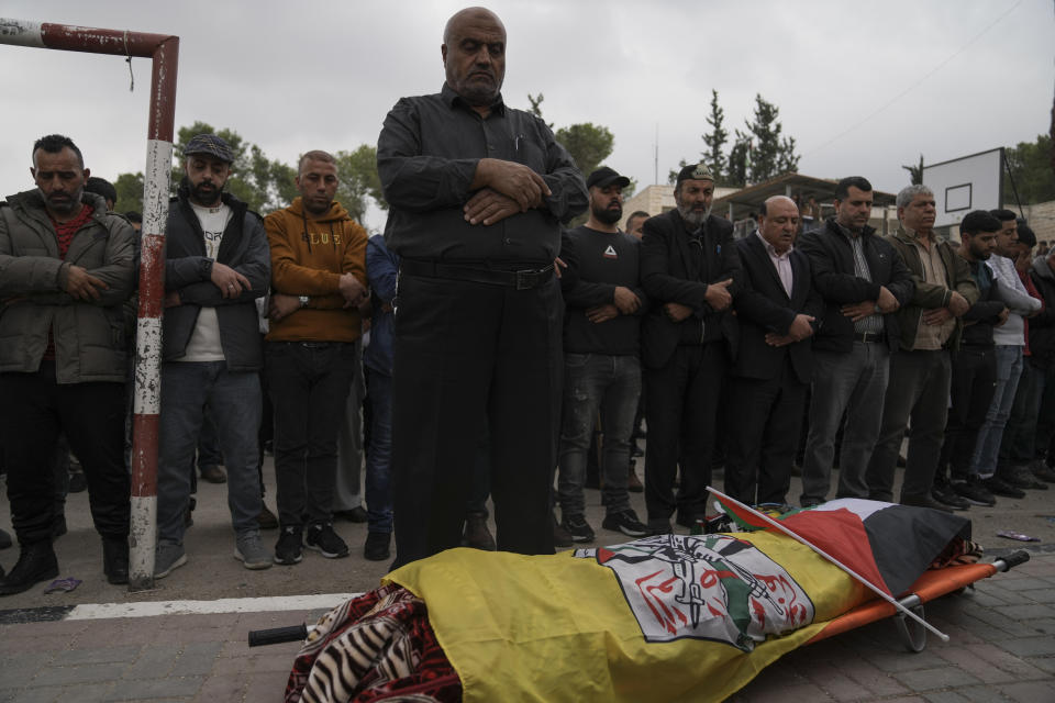 Mourners pray next to the body of Palestinian Fulla al-Masalmeh,15, during her funeral in the West Bank village of Beit Awwa, Tuesday, Nov. 15, 2022. The Palestinian Health Ministry says Israeli forces shot and killed a 15-year-old Palestinian girl during a pre-dawn raid in the occupied West Bank. The circumstances surrounding the death of the teenage girl in the city of Beitunia in the central West Bank, identified by Palestinian health officials as Fulla al-Masalmeh, were not fully clear. The Israeli military said soldiers opened fire on a vehicle that was accelerating toward them after they signaled for it to stop. The military said it was investigating, and declined to comment further. (AP Photo/Mahmoud Illean)