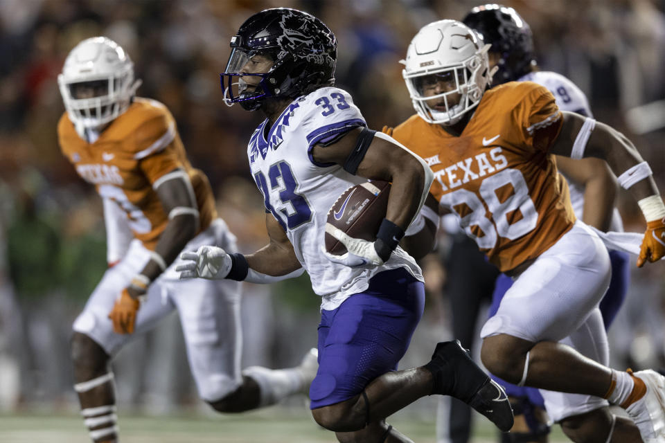 TCU running back Kendre Miller (33) runs past Texas defensive end Barryn Sorrell (88) during the second half of an NCAA college football game Saturday, Nov. 12, 2022, in Austin, Texas. (AP Photo/Stephen Spillman)