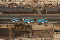 <p>Pacific Gas and Electric trucks are seen parked on a road between homes destroyed by the Tubbs Fire in Santa Rosa, Calif., Oct. 11, 2017. (Photo: Stephen Lam/Reuters) </p>